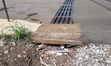 Margens da linha férrea com muito mato, lixo e entulho