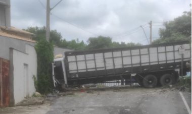 Caminhão colide com muro de residência