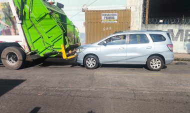 Carro bate na traseira do caminhão de lixo
