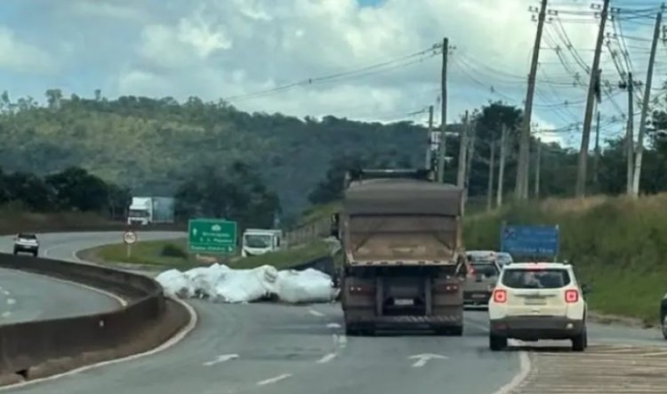 Carga de caminhão  solta e cai na rodovia